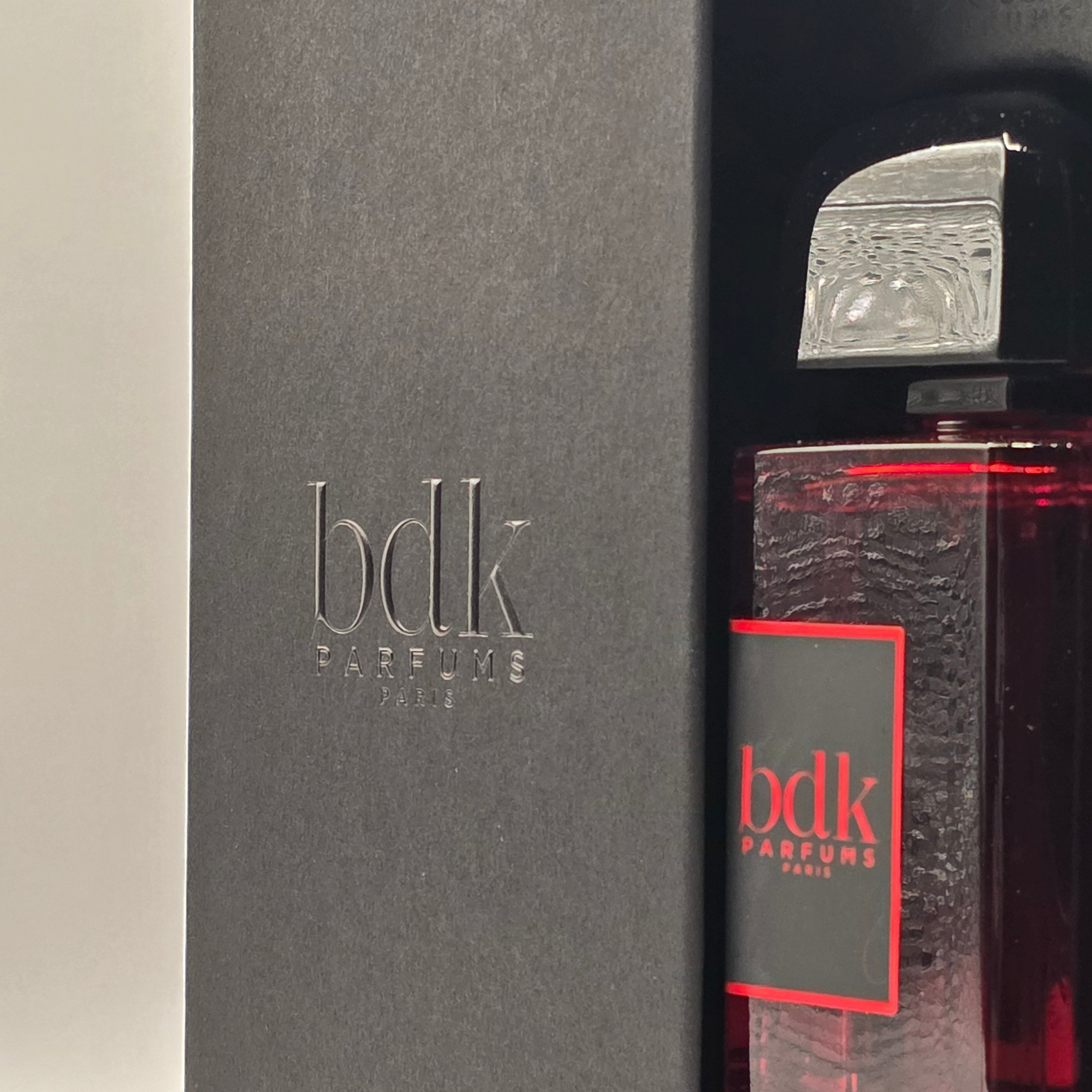 Image of BDK Parfums Rouge Smoking Extrait perfume bottle next to its black presentation box